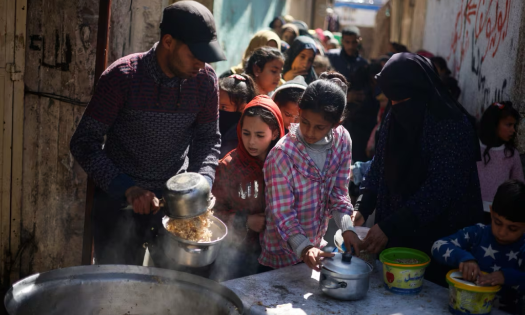 Children line up to receive food at a charity kitchen amid shortages of food supplies, in Rafah, in the southern Gaza Strip, on Tuesday. (Mohammed Salem/Reuters)