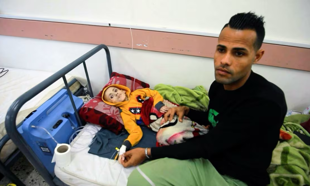 Nine-year-old Yazan al-Kafarna, with his father, Ashraf, at his side, spent his final hours in a hospital in Gaza, too weak to move. He died on Monday, one of Gaza's hunger victims. (Mohamed El Saife/CBC)