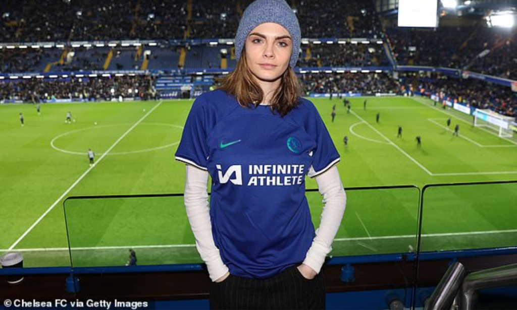 The talented star layered up with a long sleeve white top beneath her blue home kit shirt